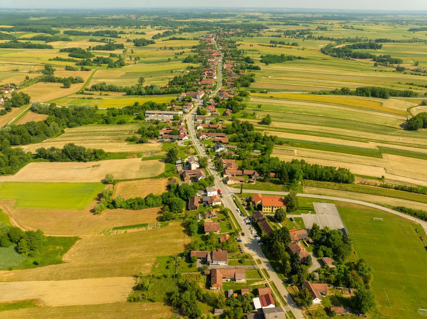 Stunning aerial photo of Velika Trnovitica's rural landscape on a sunny day, showcasing fields and village.