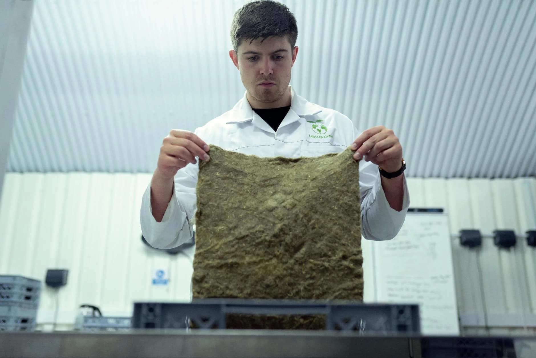 A scientist inspects a piece of biodegradable material in a laboratory setting, promoting sustainability and innovation.