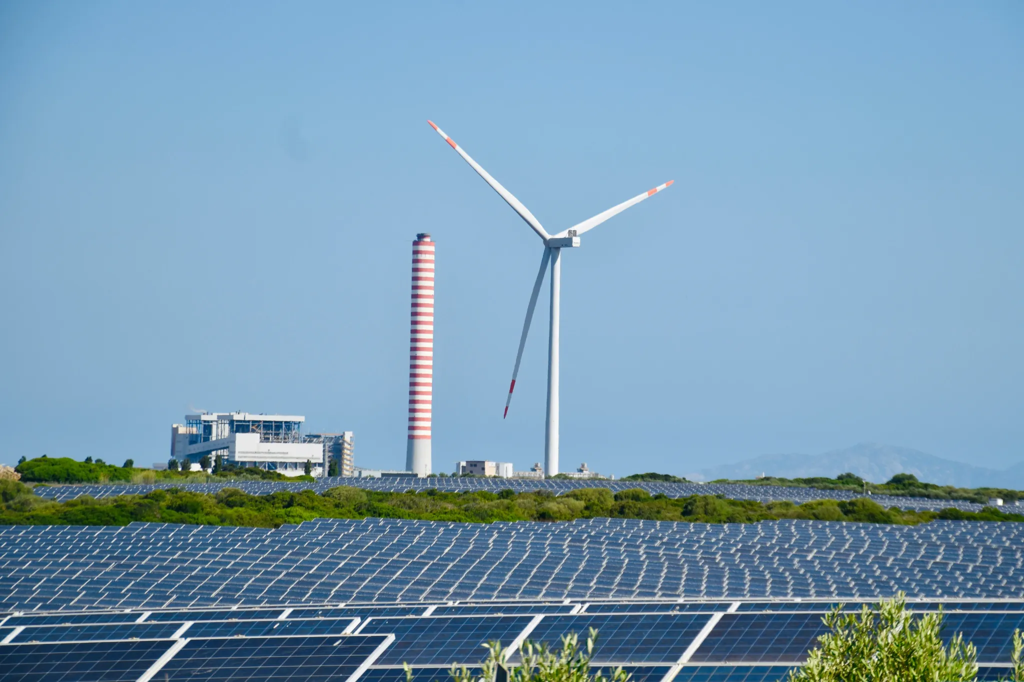 A wind farm with a wind turbine in the background