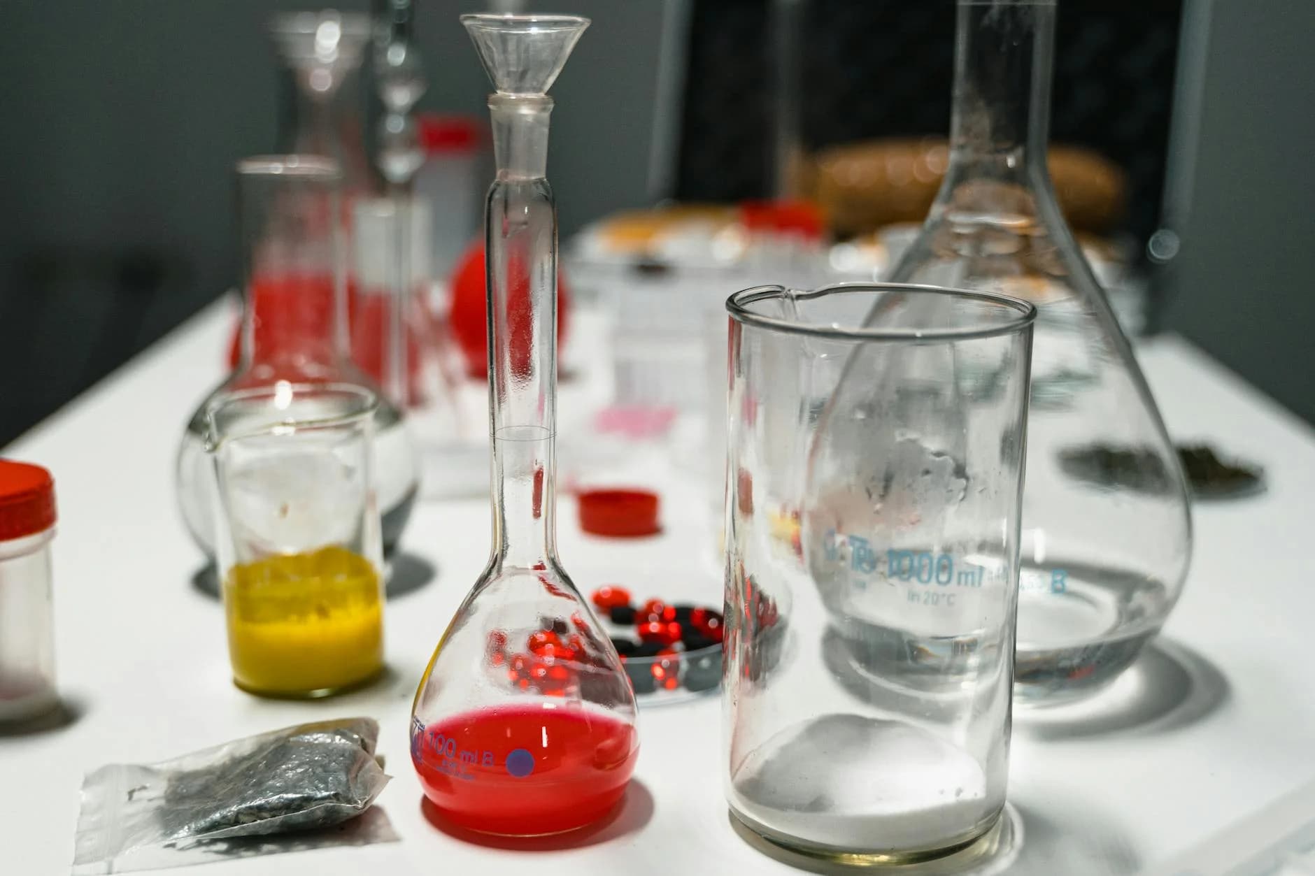 Close-up of vibrant chemical solutions in glassware on a laboratory table.