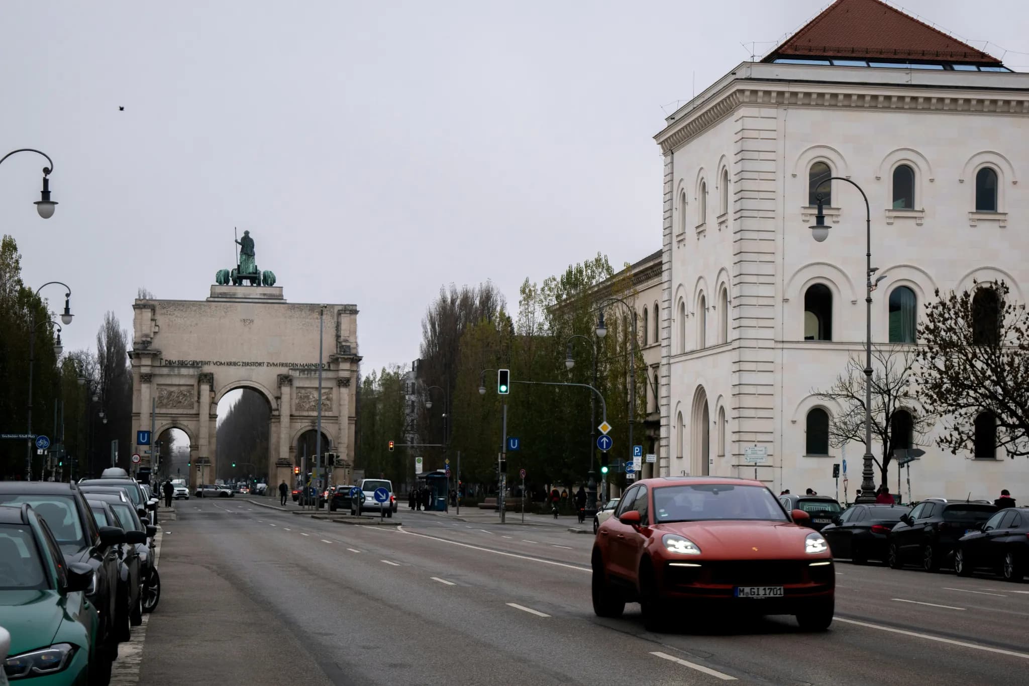 Cars driving on a city street with archway.