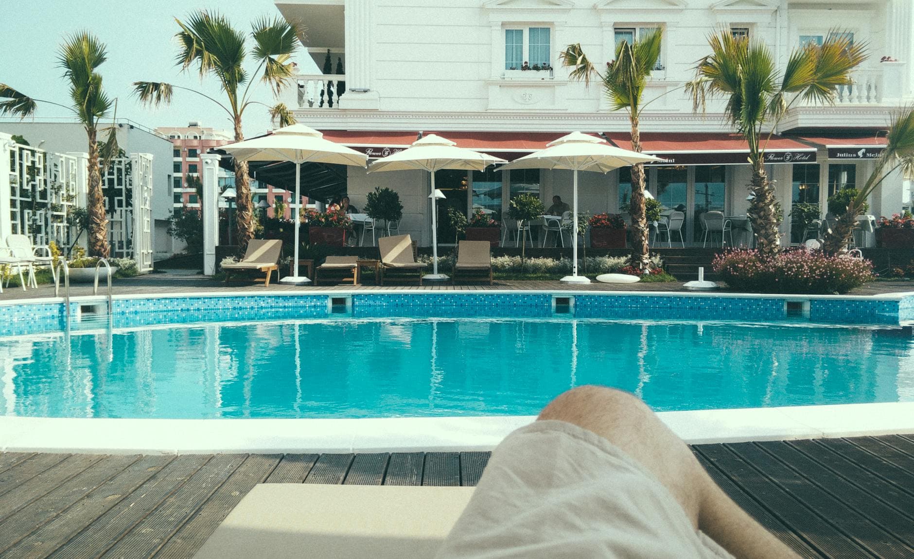 Enjoy a serene afternoon by the resort pool, perfect for relaxation and vacation getaways.