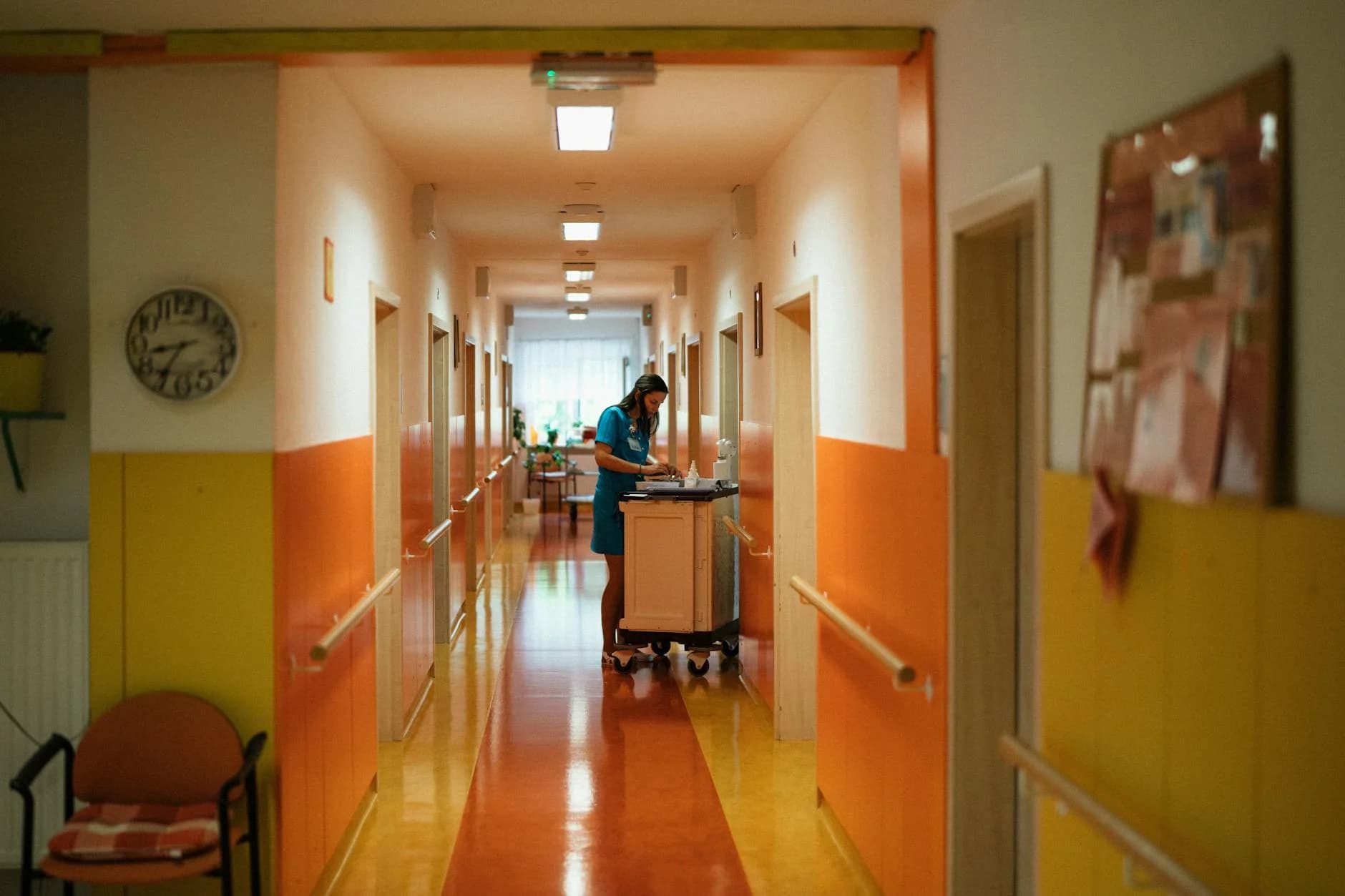 A nurse attending to duties in a colorful hospital corridor in Karviná, Czech Republic.
