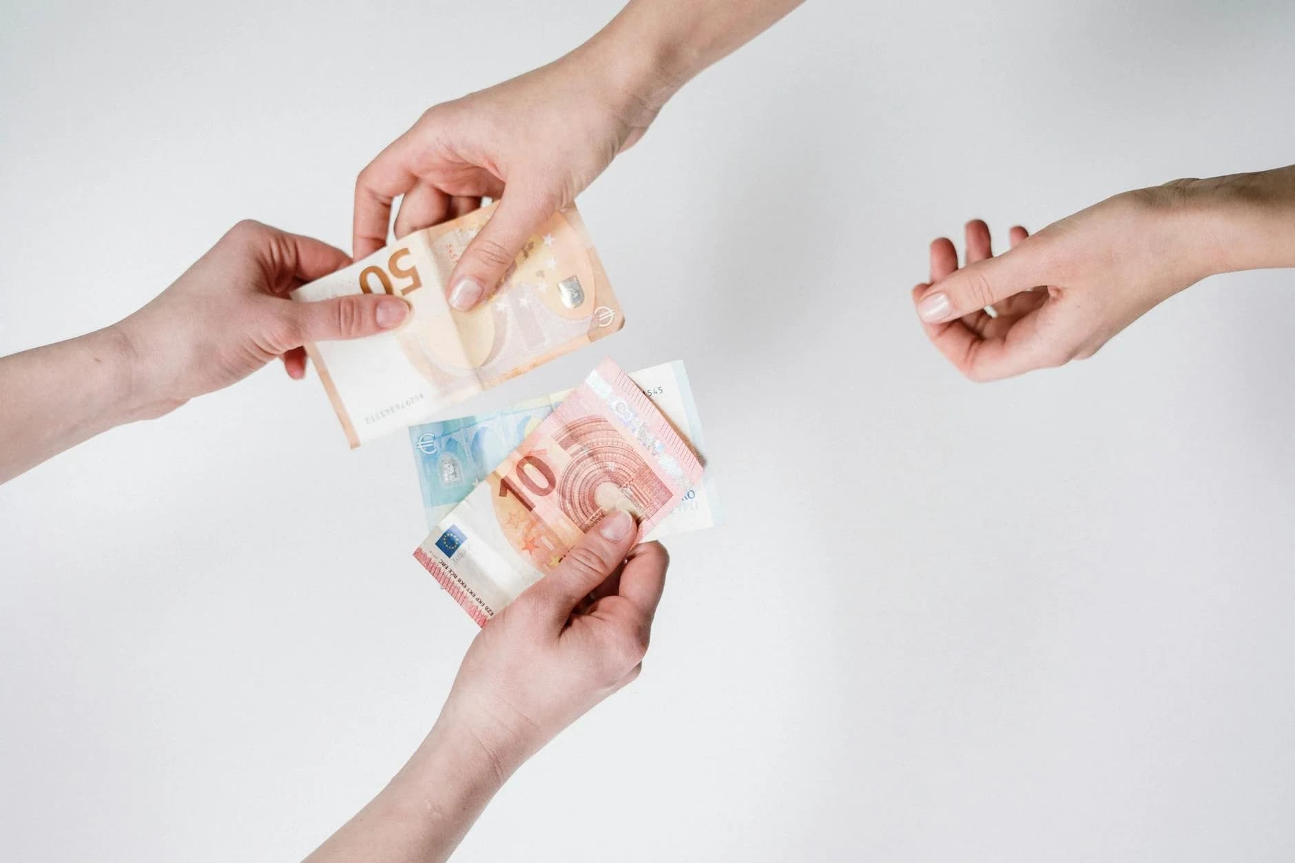 Close-up of hands exchanging euro banknotes, symbolizing currency trade and financial transactions.
