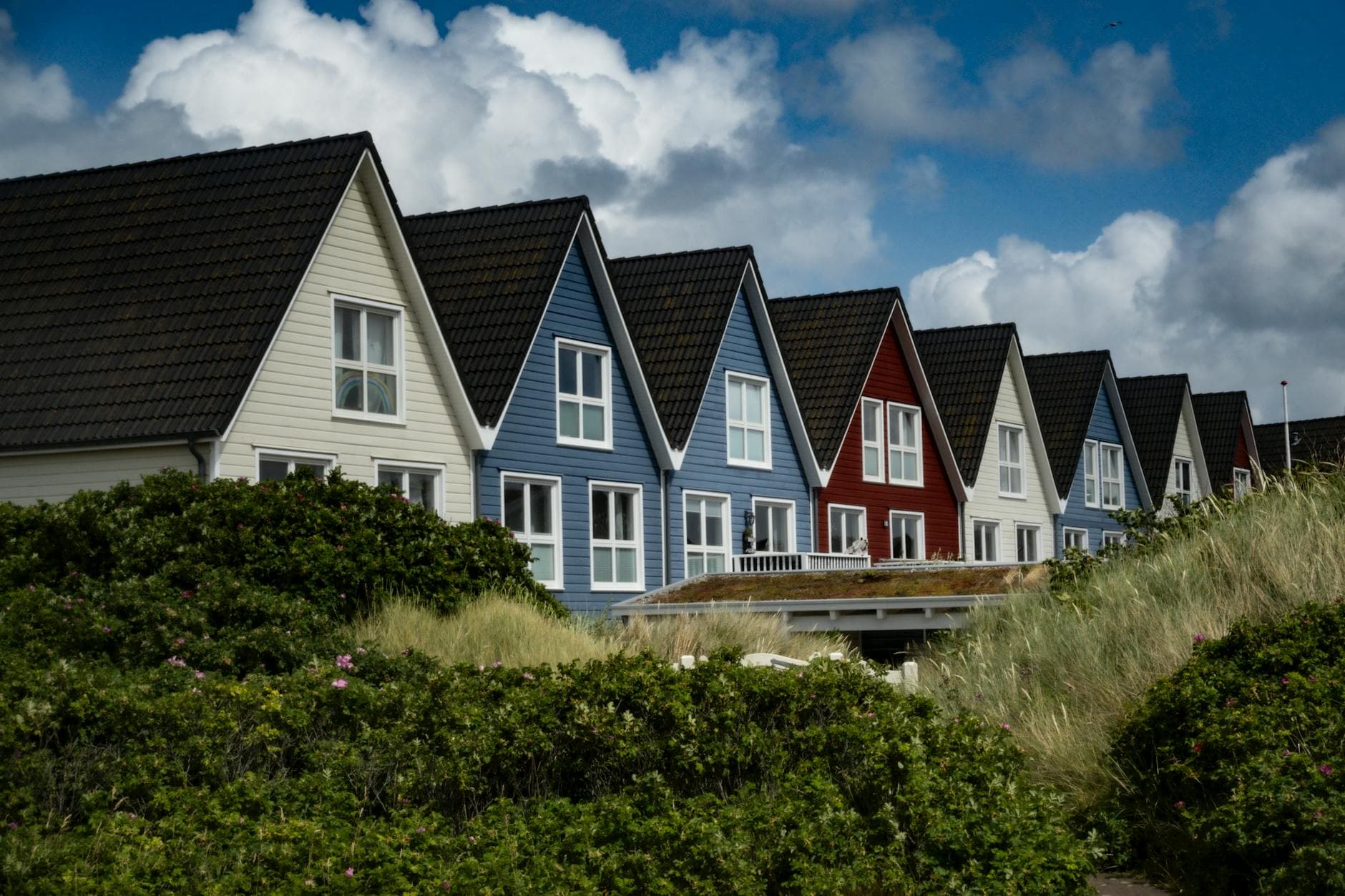 Charming Nordic row houses by the coast under a cloudy sky, highlighting traditional Scandinavian architecture.