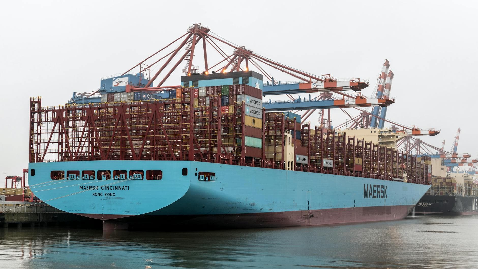 Large container ship docked with cranes at Hamburg Port, Germany.