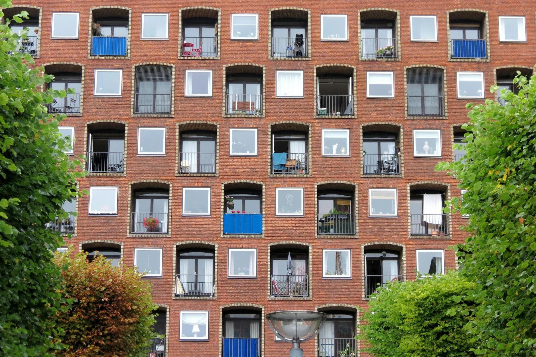 Symmetrical windows of a red brick apartment building in Copenhagen, Denmark.