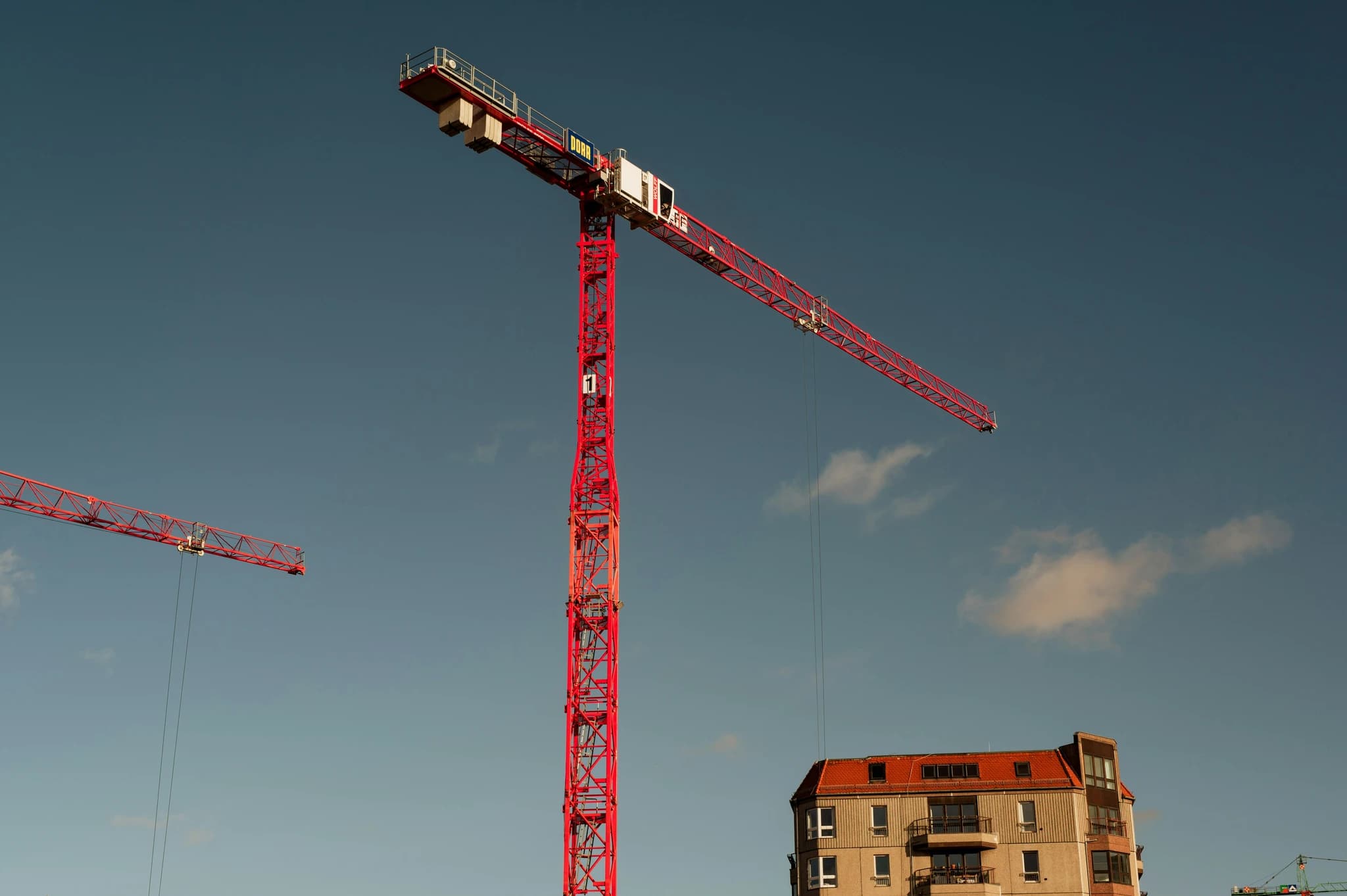 red and white crane under blue sky during daytime