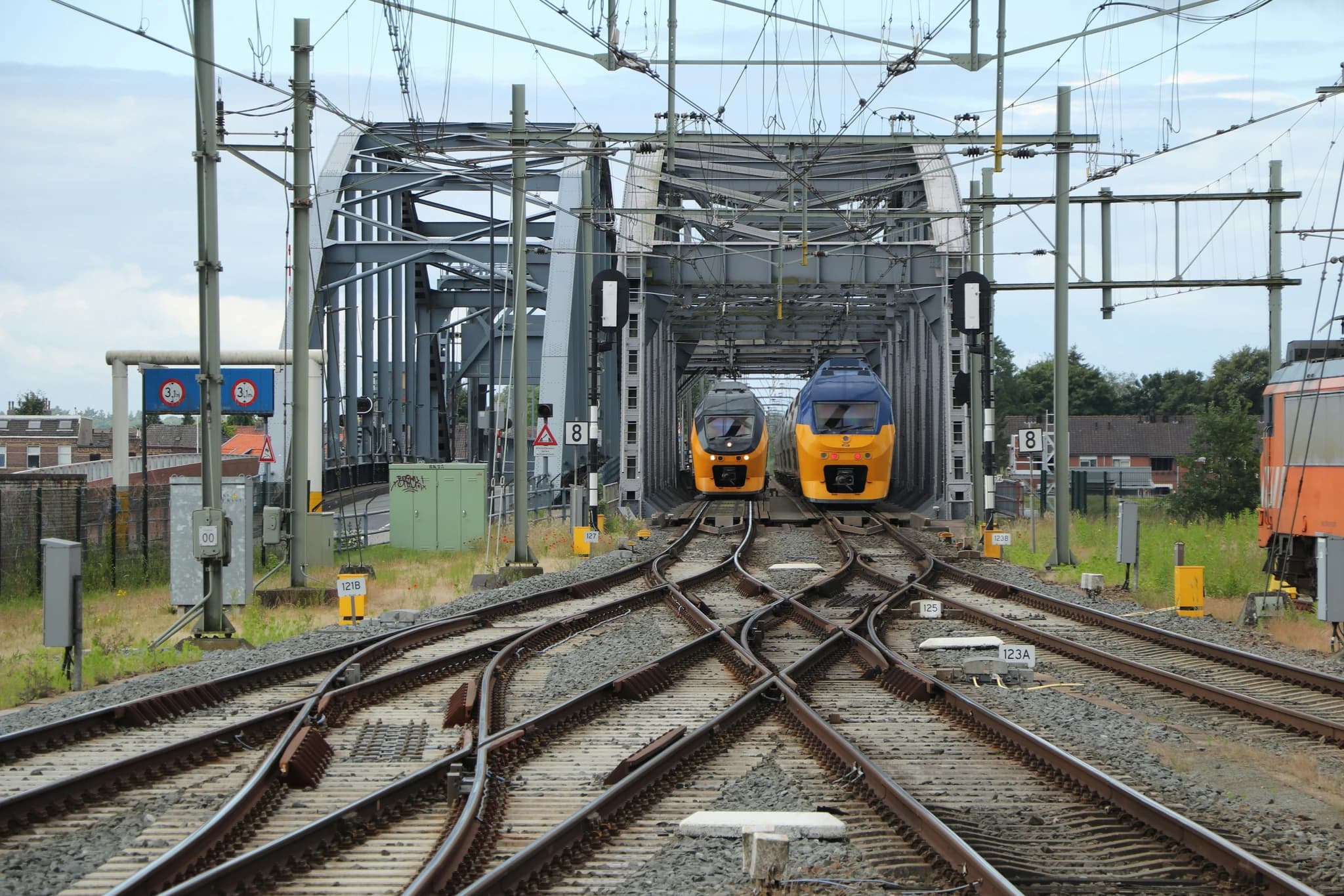 Two yellow trains approaching a bridge crossing