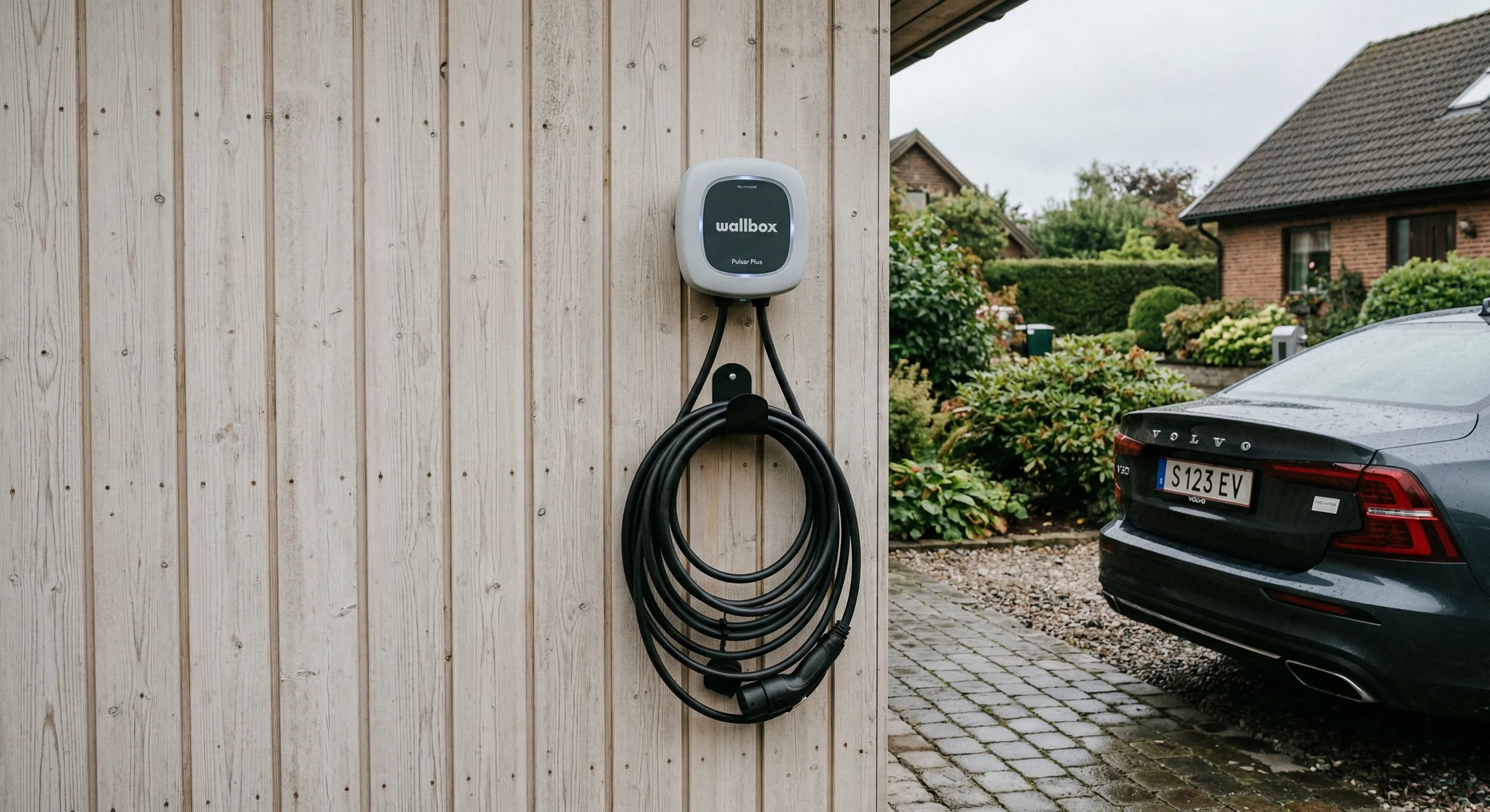 Elektrisk firmabil der lades op ved en privat bolig.